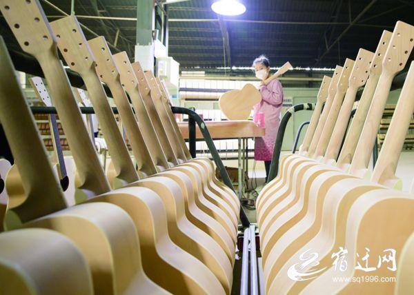 10月13日,沭阳县桑墟镇欧利屋乐器厂的车间,工人正在为吉他进行打磨
